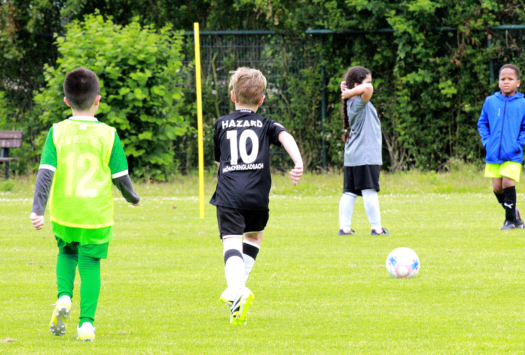Kinder im Laufduell mit Ball